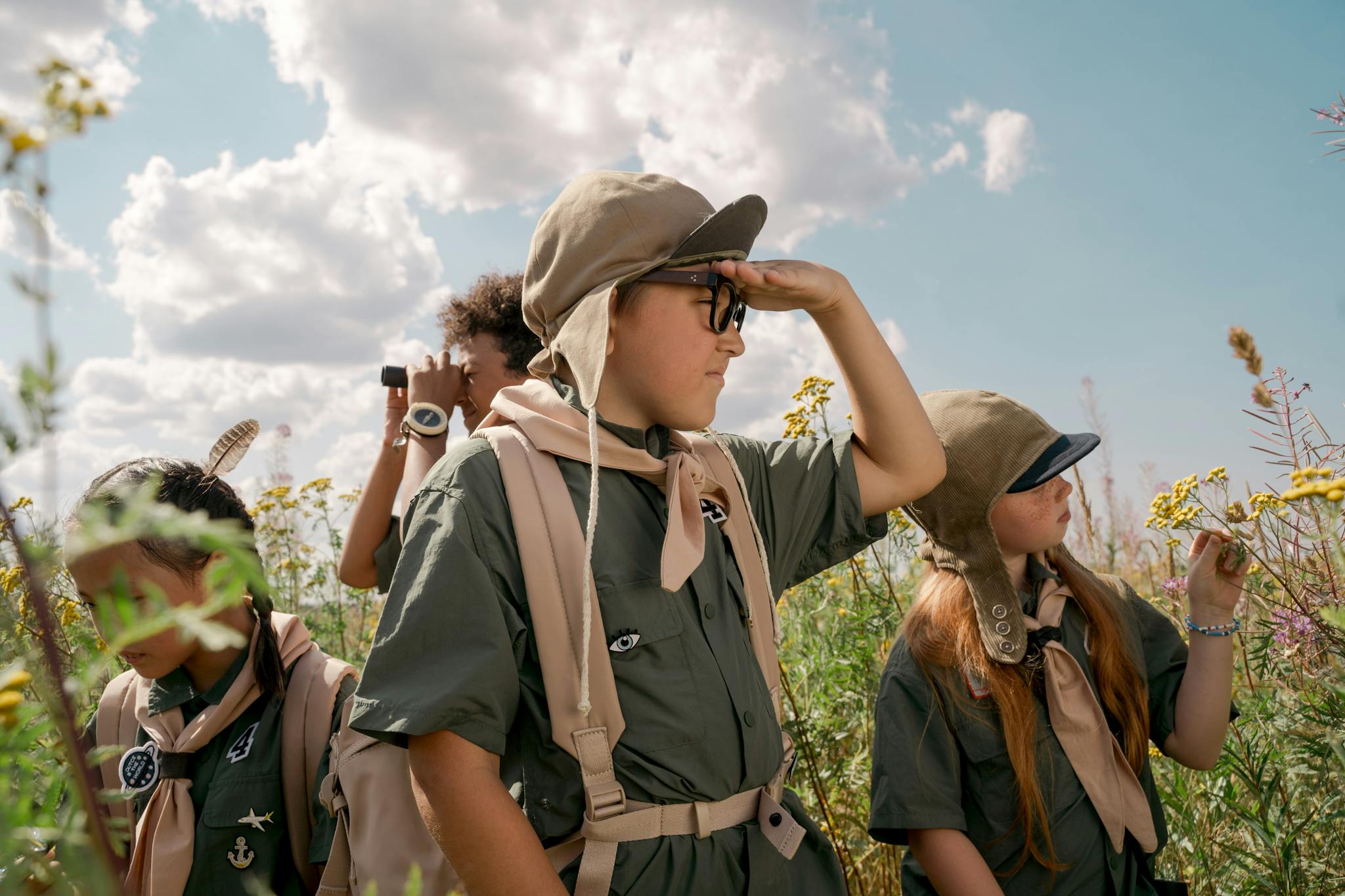 Children's scouting adventure in summer outdoors, exploring nature and field.